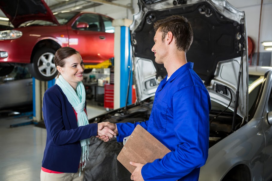 Satisfied customer shaking hands with mechanic at repair garage Professional Car Consulting Sydney
