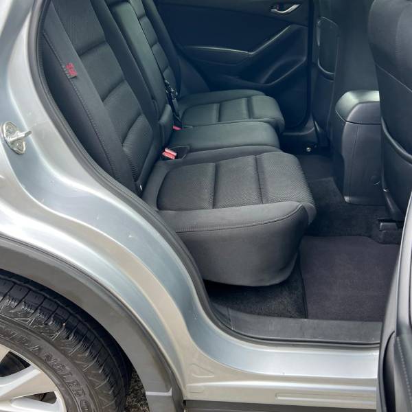 A detailer wiping a black car's body with a cloth after applying Ceramic Coating
